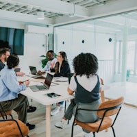 a group of people sitting around a table in a conference room